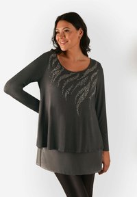 Maglia grigia scura a maniche lunghe con scollatura a girocollo, caratterizzata da un motivo di strass che ricorda linee fluide, con dettaglio di orlo trasparente a strati.