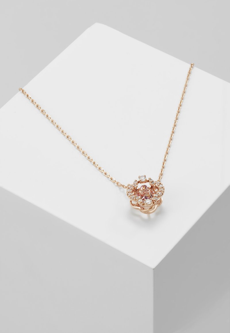 Collier en or rose avec un design floral mettant en avant une pierre rose centrale entourée de petites pierres claires sur une chaîne délicate.