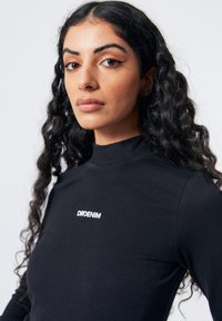 Schwarzes Langarmshirt mit hohem Kragen und weißem "DRDENIM"-Logo auf der Brust, verfügt über eine glatte Textur und eine enganliegende Passform.