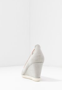 Scarpa wedge in suede grigio chiaro con pannello laterale in rete e un accento arancione a contrasto; presenta un tacco testurizzato e suola in gomma.
