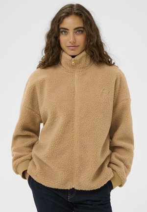 Beige Fleecejacke mit hohem Kragen, vollem Reißverschluss und elastischen Bündchen. Mit einer strukturierten Oberfläche und minimaler Markenkennzeichnung auf der Brust.
