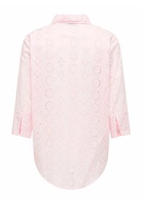 Svijetloružičasta košulja s ovratnikom na kopčanje, ukrašena izvezenim proreznim uzorcima i rukavima tri četvrtine s prorezima. Zaobljeni rub.