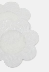 White floral-shaped adhesive patches with a textured surface and smooth center, showcasing scalloped edges and minimal design details.