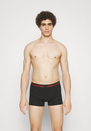 Schwarze Boxershorts mit rotem "JACK & JONES"-Bund, eng anliegendes Design, elastisches Material, getragen von einem Modell mit kurzen, lockigen Haaren.