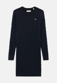 Abito in maglia a treccia color blu navy scuro. Presenta maniche lunghe, scollo a costine e un piccolo logo ricamato sul petto.