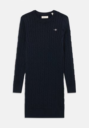Cable-knit sweater dress in dark navy. Features long sleeves, ribbed neckline, and a small embroidered logo on the chest.