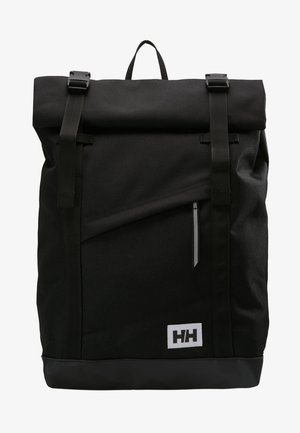 Mochila negra tipo roll-top hecha de material duradero, con correas ajustables, un bolsillo con cremallera en la parte frontal y un parche con el logo en la parte inferior. Diseño minimalista.