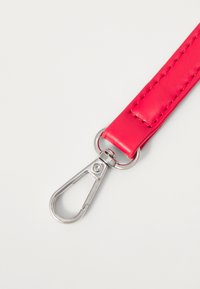 Helderroze synthetische band met een gladde textuur, voorzien van een zilveren metalen clip aan één uiteinde voor bevestiging.