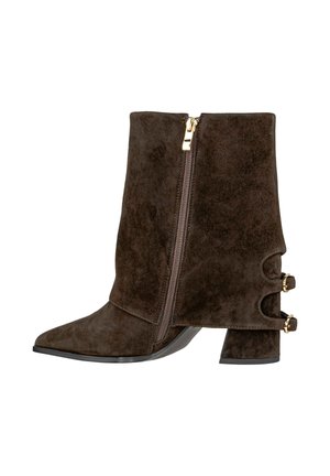 Stivaletti in suede marrone con punta appuntita, cerniera laterale e dettagli in metallo dorato. Presentano un tacco blocco elegante e ritagli decorativi.