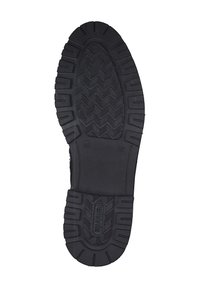 Semelle de chaussure en caoutchouc noir avec un motif de crampons prononcé, des bords épais et un détail de logo. La texture est lisse avec des rainures profondes pour une meilleure adhérence.