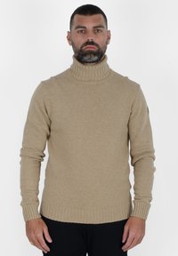 Maglione a collo alto beige realizzato in morbido tessuto a maglia, con polsini e orlo a costine, dal fit slim e senza motivi o decorazioni.