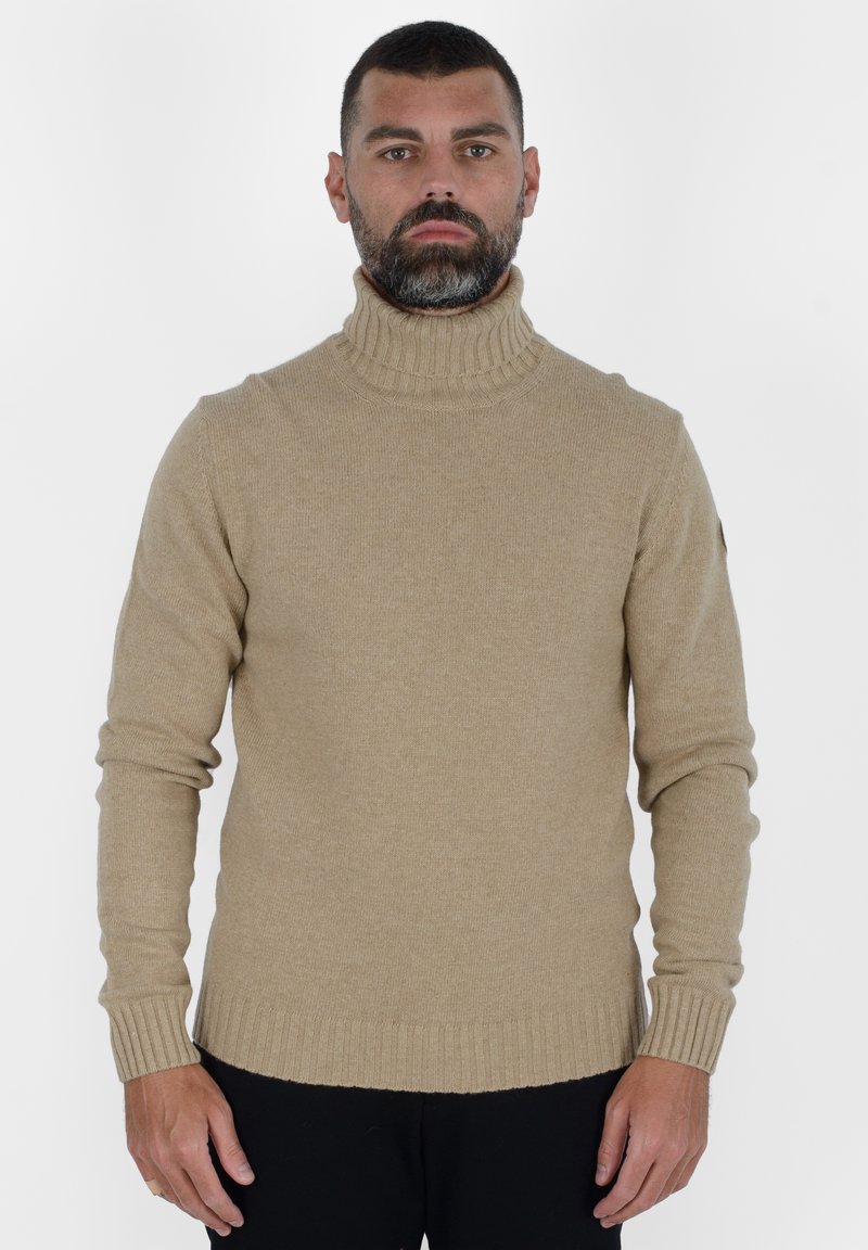 Maglione a collo alto beige realizzato in morbido tessuto a maglia, con polsini e orlo a costine, dal fit slim e senza motivi o decorazioni.