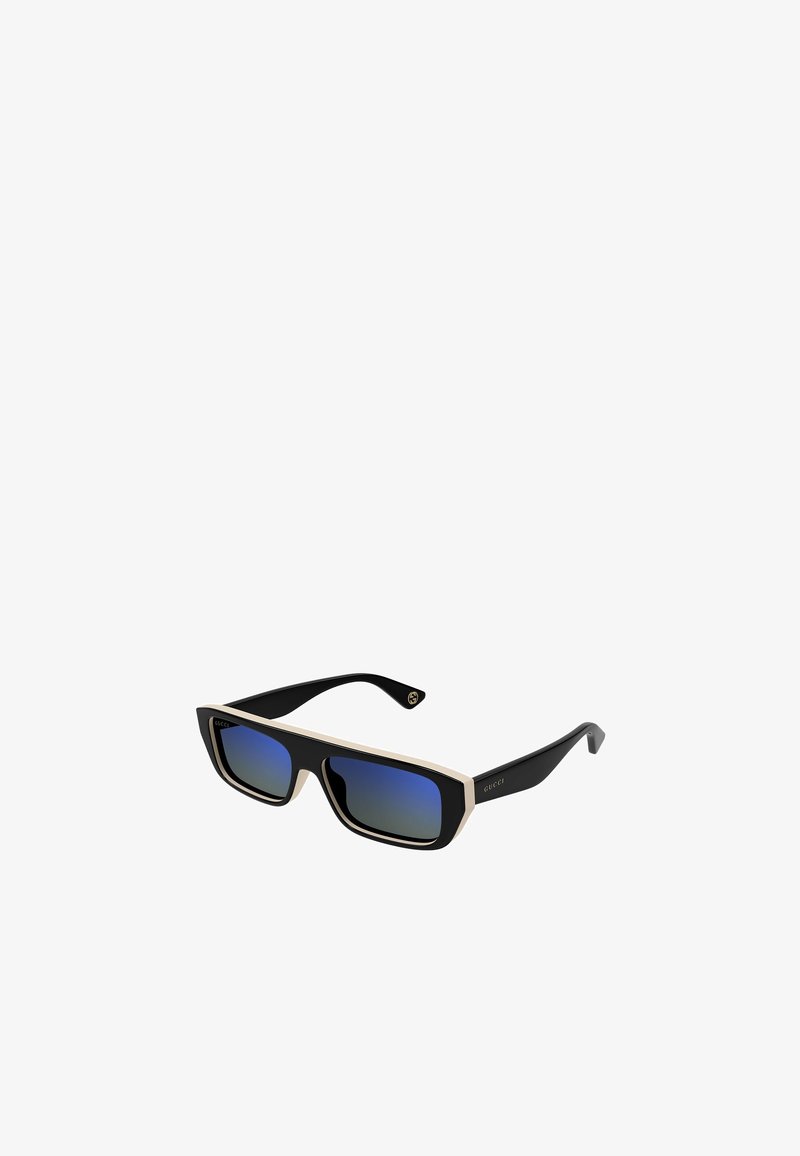 Lunettes de soleil noires avec une monture supérieure épaisse couleur crème, des verres dégradés bleus et des branches noires avec un accent logo doré.