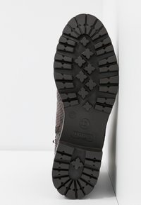 Semelle d'une botte marron texturée avec un motif de semelle profonde, taille 37, et la marque "Dune London" sur la zone du talon.