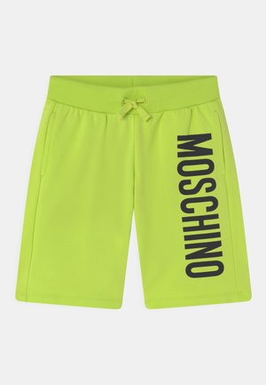 Neonowe zielone szorty z miękkiego materiału, z żebrowanym paskiem w talii, regulowanym sznurkiem i dużym czarnym napisem "MOSCHINO" po boku.