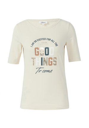 Gaiši bežs īsām piedurknēm T-krekls, izgatavots no mīksta auduma. Tam ir daudzkrāsaini uzraksti dažādās fontu formās, un vārds "GOOD" ir ar metālisku spīdumu.