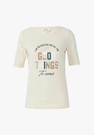 Camiseta de manga corta color beige claro hecha de tela suave. Presenta texto multicolor en varias fuentes, con un brillo metálico en "BUENO".