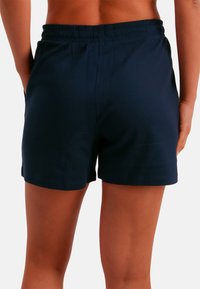 Pantalones cortos de algodón azul marino con cintura elástica, bolsillos laterales y un diseño simple y funcional sin patrones ni adornos.