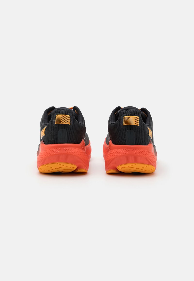 Zapatillas deportivas negras y naranjas con parte superior texturizada, cuello acolchado y suela de goma naranja distintiva. Presenta llamativos acentos amarillos en el talón.
