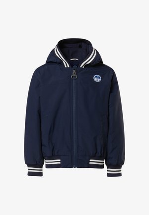 Marineblaue Jacke mit Kapuze, Frontreißverschluss und weißen gestreiften Bündchen. Verfügt über ein rundes Logo auf der Brust und ein glattes, leichtes Material.