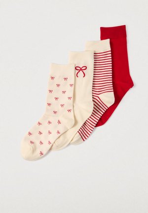 Trois paires de chaussettes : une crème avec de petits nœuds rouges, une crème à rayures rouges, et une paire unie rouge. Tissu doux, longueur mi-mollet.