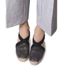 Černé espadrilky s květinovým vzorem a spletenou juteovou podrážkou. Elastické křížové popruhy přes nohu s texturovaným povrchem.