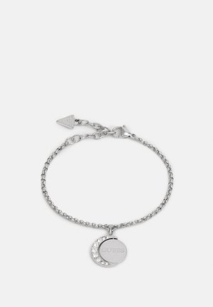 Bracelete de corrente prateada com um pendente em forma de lua circular e crescente, com adornos em strass e uma etiqueta de marca. Fecho ajustável.