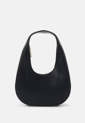 Mustan sirpinmuotoinen nahkalaukku, jossa on yläkahva ja kultainen vetoketjun vetolaite, yksinkertaista valkoista taustaa vasten.