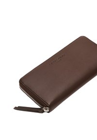 Brązowy skórzany portfel o gładkiej fakturze, z zamkiem błyskawicznym oraz małym skórzanym uchwytem. Z przodu znajduje się wytłaczane logo.