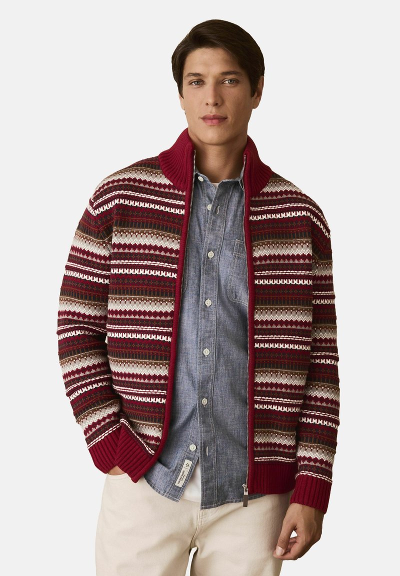Knit cardigan with a maroon base, featuring horizontal stripes in beige, green, and red. Ribbed cuffs and collar; front zipper closure.