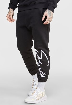 SCRIPT EMBROIDERY - Tracksuit bottoms - black