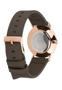 LIEBESKIND horloge met een bruine siliconen band, kast van rosegoud roestvrij staal, heldere glazen achterkant en merknaam gegraveerd op de sluiting.