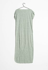 Lång, ljusgrön klänning i mjukt, texturerat tyg. Har en rund halsringning och korta ärmar. Hänger från en svart krok.