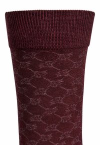 Calzino bordeaux con polsino a coste, caratterizzato da un motivo geometrico in una tonalità più chiara. Realizzato in un tessuto morbido e elastico per il massimo comfort.