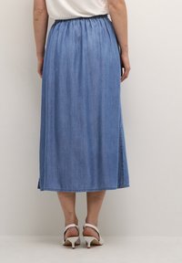 Džínsová midi sukně s nařaseným pasem, světle modrá barva a rozparky na obou stranách, vyrobená z hladké, texturované látky.