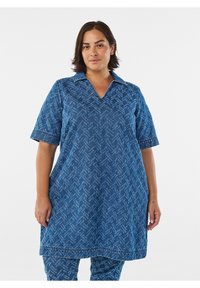 Jeanstunika i blått med fiskbensmönster, korta ärmar och krage. Lös passform med sydda detaljer.