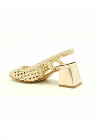 Scarpa slingback in oro intrecciato con punta affilata, dotata di tacco metallico spesso e design con ritagli per una maggiore traspirabilità.
