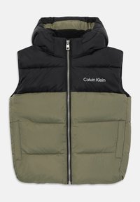 Podložena brezrokavnik s črnim kapuco in olivno zelenim spodnjim delom. Ima srednji zadrgo in belim logotipom "Calvin Klein" na prsih.