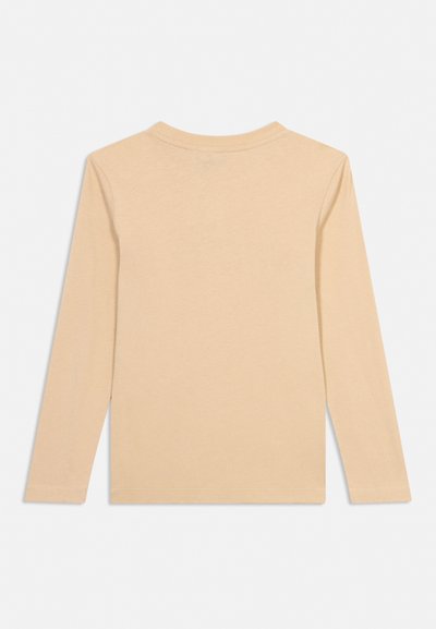 Beżowa koszulka z długim rękawem i okrągłym dekoltem, rozłożona na płasko, widziana od tyłu, pokazująca proste przeszycia i gładką teksturę tkaniny.