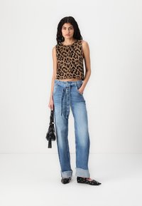 Top s leopardím vzorem bez rukávů v hnědé a černé barvě; světle modré džíny s vysokým pasem a vázacím páskem; černé baleríny s výřezovým zdobením.