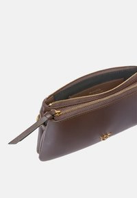 Smeđa kožna torbica s zlatnim patentnim zatvaračem, glatke teksture i detaljem s logotipom. Ima tanak, pravokutni oblik i odjeljak sa zatvaračem.