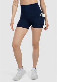 Marina högmidjade träningsshorts gjorda av stretchigt material, med en sidoficka för en smartphone. Slät textur med platta sömmar.