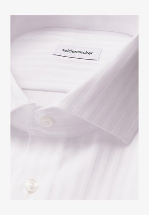 Biała koszula z cienkimi pionowymi paskami, z zapięciem na guziki przy kołnierzy oraz widoczną metką marki "seidensticker" wewnątrz dekoltu.