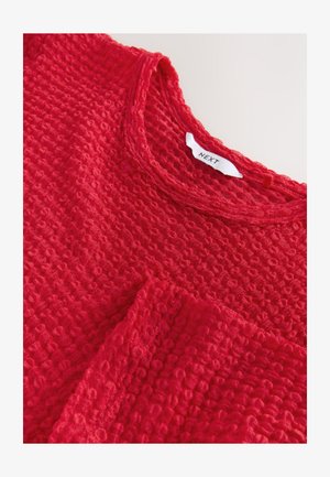 Červený textúrovaný top s okrúhlym výstrihom a štítkom NEXT. Látka má tkaný, vzorovaný povrch a uvoľnený strih.