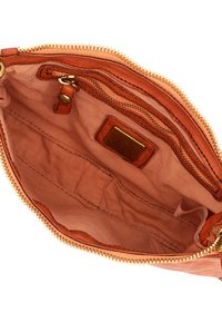 Interno di una borsa in pelle tan, con una tasca con cerniera, foderato in tessuto liscio e accessori in tonalità oro con dettagli cuciti.