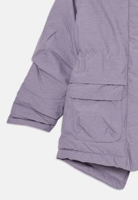 Manteau rembourré violet avec une manche et une poche frontale inférieure à rabat, montrant un tissu texturé et des détails cousus sur fond blanc.