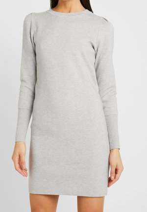 Robe en tricot gris à manches longues, col rond et subtilement détaillée aux épaules. Texture douce et design ajusté, se terminant au-dessus du genou.