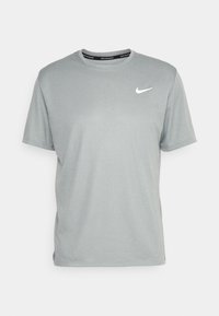 Camiseta atlética de manga corta en color gris, hecha de un tejido suave, que presenta un logo blanco de Nike en el pecho y un cuello redondo negro con marca.