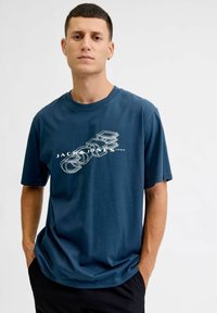 Granatowa bawełniana koszulka z krótkim rękawem, z okrągłym dekoltem, z białym rysunkiem aparatu oraz napisem "JACK & JONES 1990" na przodzie.