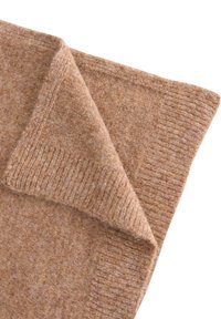 Brun fleecefilt med en mjuk, texturerad yta. Har ett vikt hörn och en ribbad kantdetalj för ökad visuell intresse.